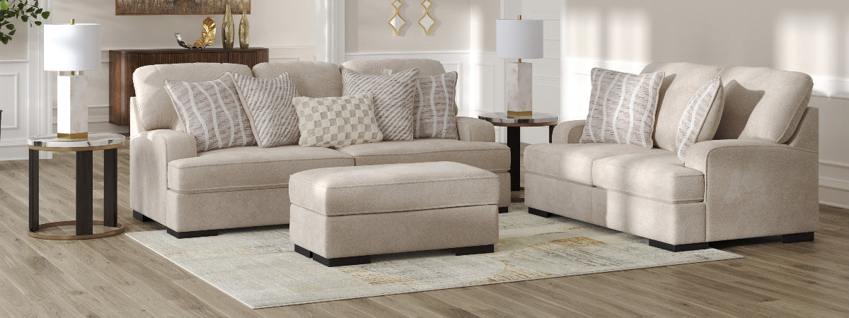 Beige sectional sofa set in a living room setting with decorative pillows and side tables.